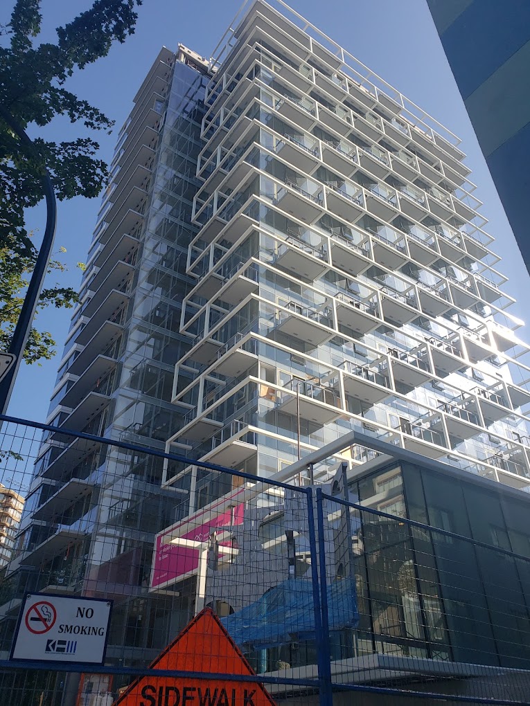 apartment building with multiple stories and blue sky background