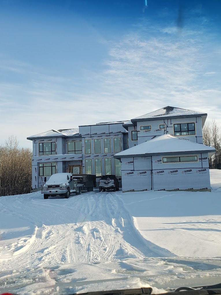 Home in Edmonton under construction.  Snow on the ground and blue sky.